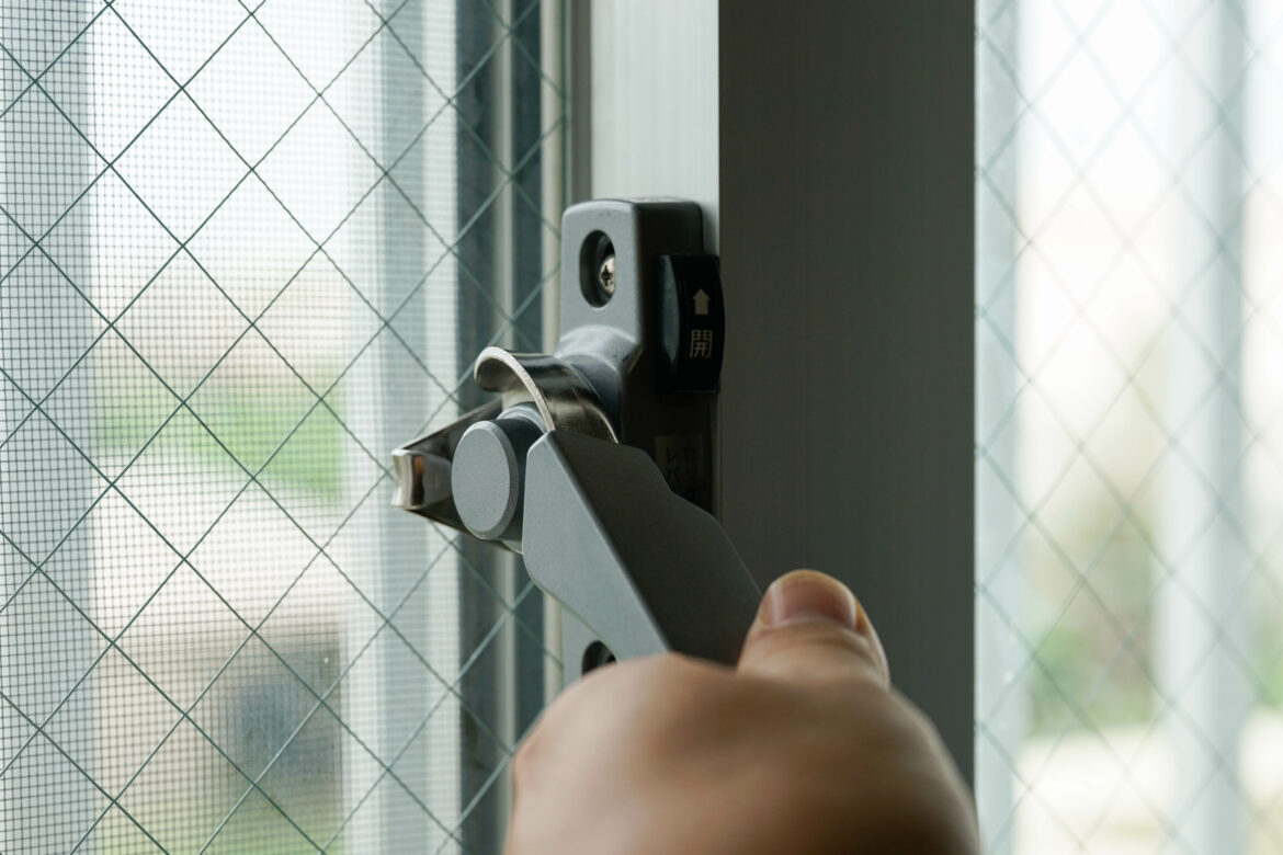 窓のカギを閉める手